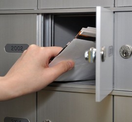 hand putting mail into a private mailbox